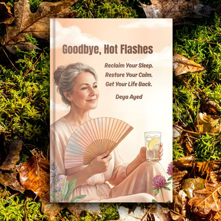 Book titled 'Goodbye, Hot Flashes' on a background of green moss and fallen leaves